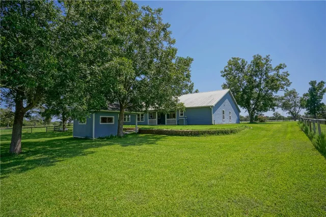 a view of a house with backyard and garden