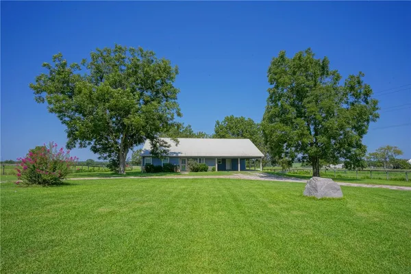 a house with green field in front of it