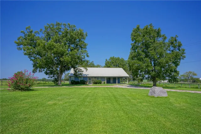 a house with green field in front of it