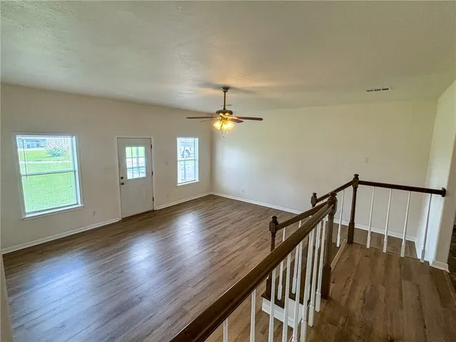 a large kitchen with cabinets wooden floor and stainless steel appliances