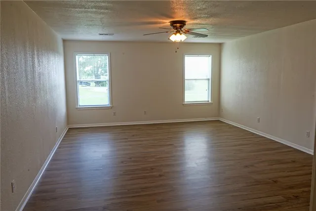 a view of a room with wooden floor and fan