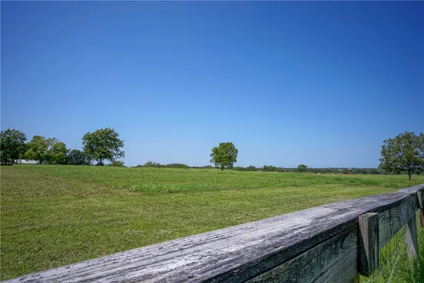 a view of a field of grass and trees