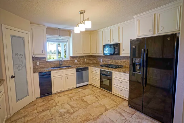 a kitchen with a refrigerator stove and sink