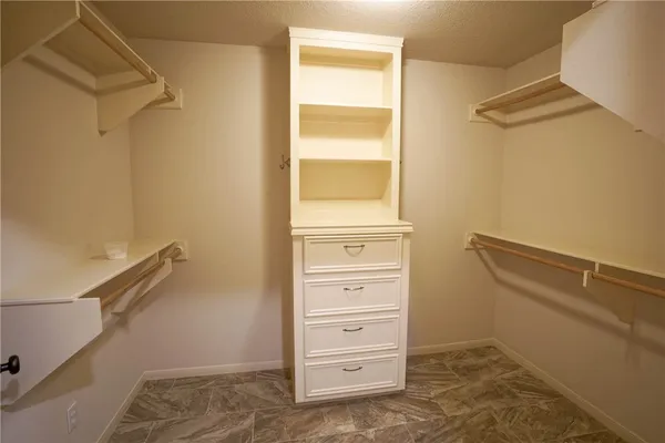a view of walk in closet with empty racks