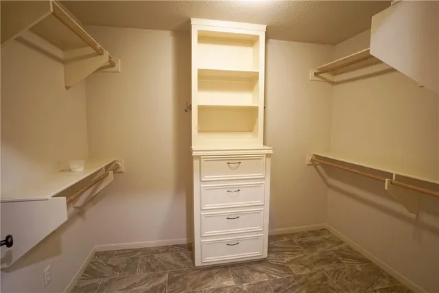 a view of walk in closet with empty racks