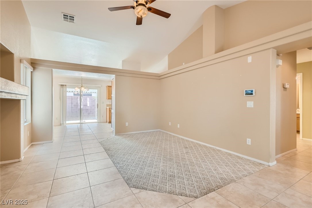 7550 Slipstream Street Las Vegas, NV 89139 - Photo 11 of 33 Spare room featuring high vaulted ceiling, light tile patterned floors, a chandelier, and ceiling fan