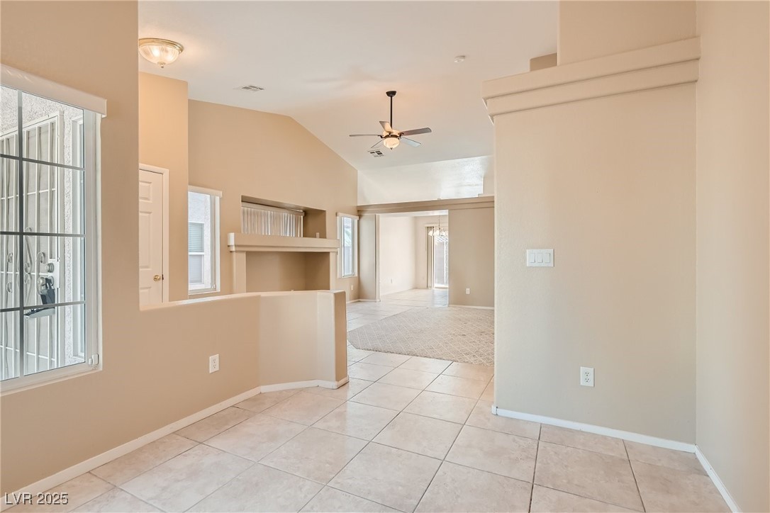 7550 Slipstream Street Las Vegas, NV 89139 - Photo 15 of 33 Spare room featuring light tile patterned flooring, a ceiling fan, and vaulted ceiling