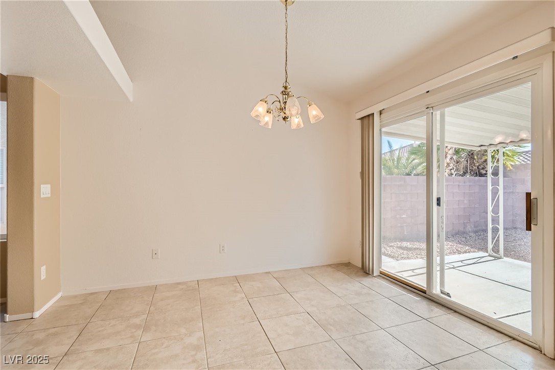 7550 Slipstream Street Las Vegas, NV 89139 - Photo 20 of 33 Empty room featuring light tile patterned floors and a chandelier