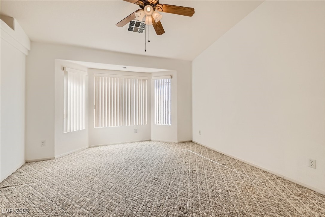 7550 Slipstream Street Las Vegas, NV 89139 - Photo 22 of 33 Empty room with carpet flooring, a ceiling fan, and vaulted ceiling