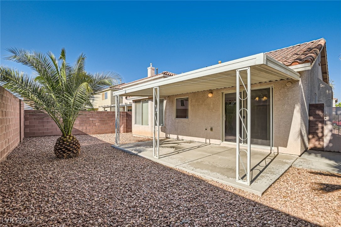7550 Slipstream Street Las Vegas, NV 89139 - Photo 31 of 33 Rear view of house featuring stucco siding, a fenced backyard, a patio area, and a tile roof