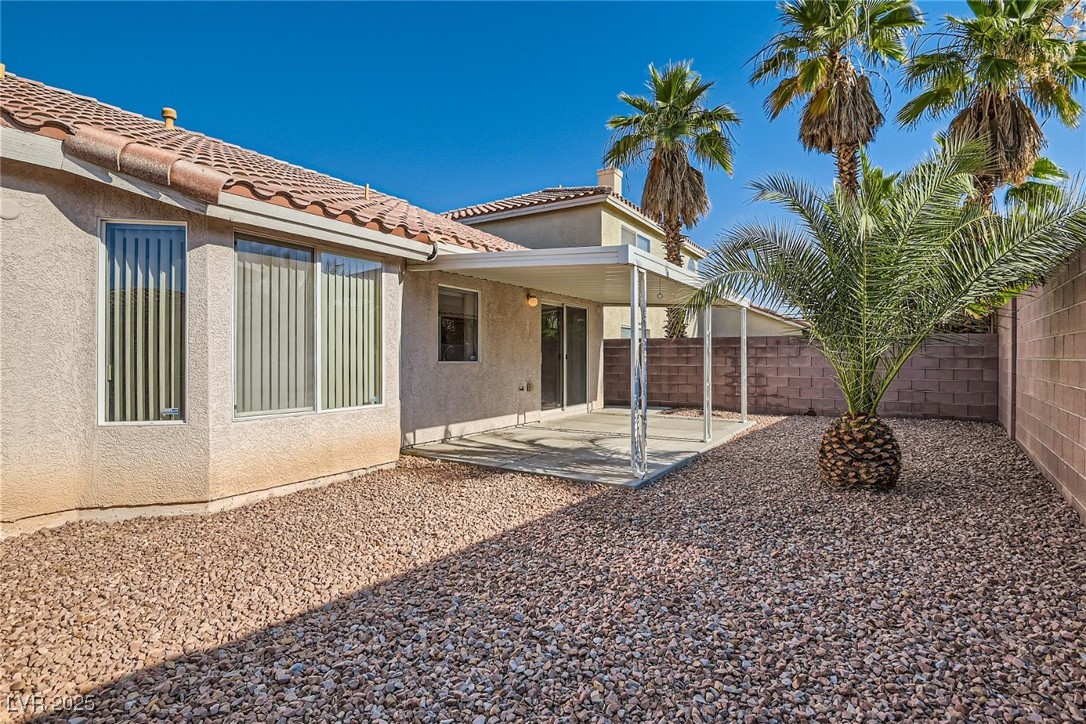 7550 Slipstream Street Las Vegas, NV 89139 - Photo 32 of 33 Rear view of property featuring a patio, stucco siding, a fenced backyard, and a tile roof