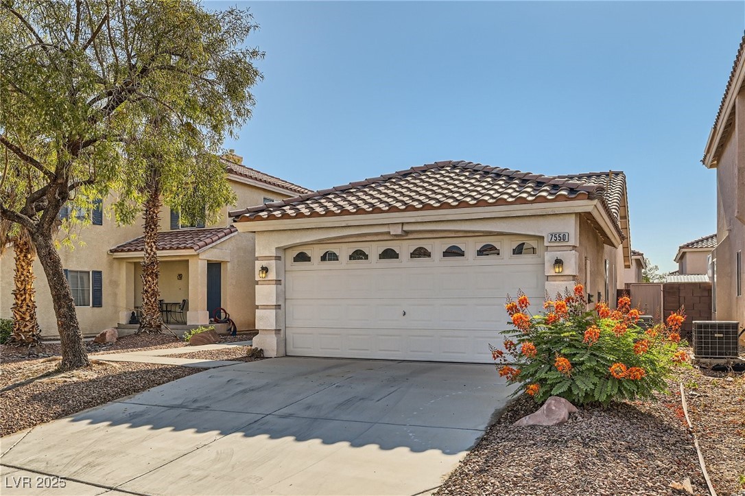 7550 Slipstream Street Las Vegas, NV 89139 - Photo 6 of 33 Mediterranean / spanish home with stucco siding, driveway, a tiled roof, and an attached garage