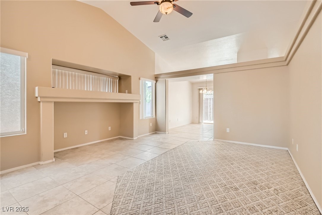 7550 Slipstream Street Las Vegas, NV 89139 - Photo 10 of 33 Unfurnished room featuring light tile patterned floors, high vaulted ceiling, a ceiling fan, and a chandelier