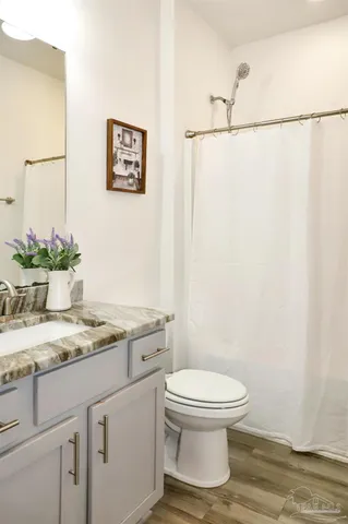 a bathroom with a granite countertop sink toilet and a mirror