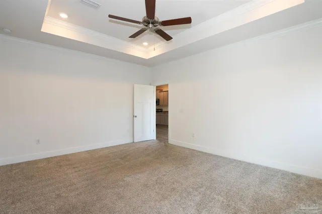 an empty room with an entryway and fan