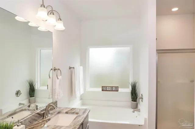 a bathroom with a bathtub a sink and a mirror