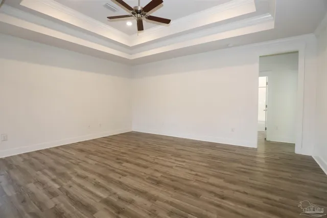 a view of a room with wooden floor and a ceiling fan