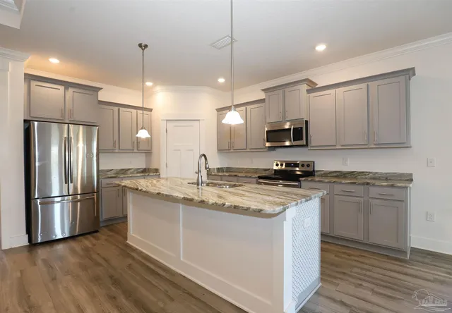 a kitchen with stainless steel appliances granite countertop a refrigerator a stove a sink and a microwave