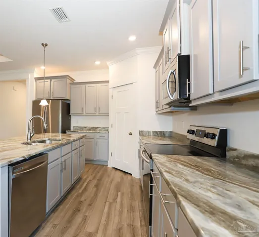 a kitchen with a sink a stove and cabinets