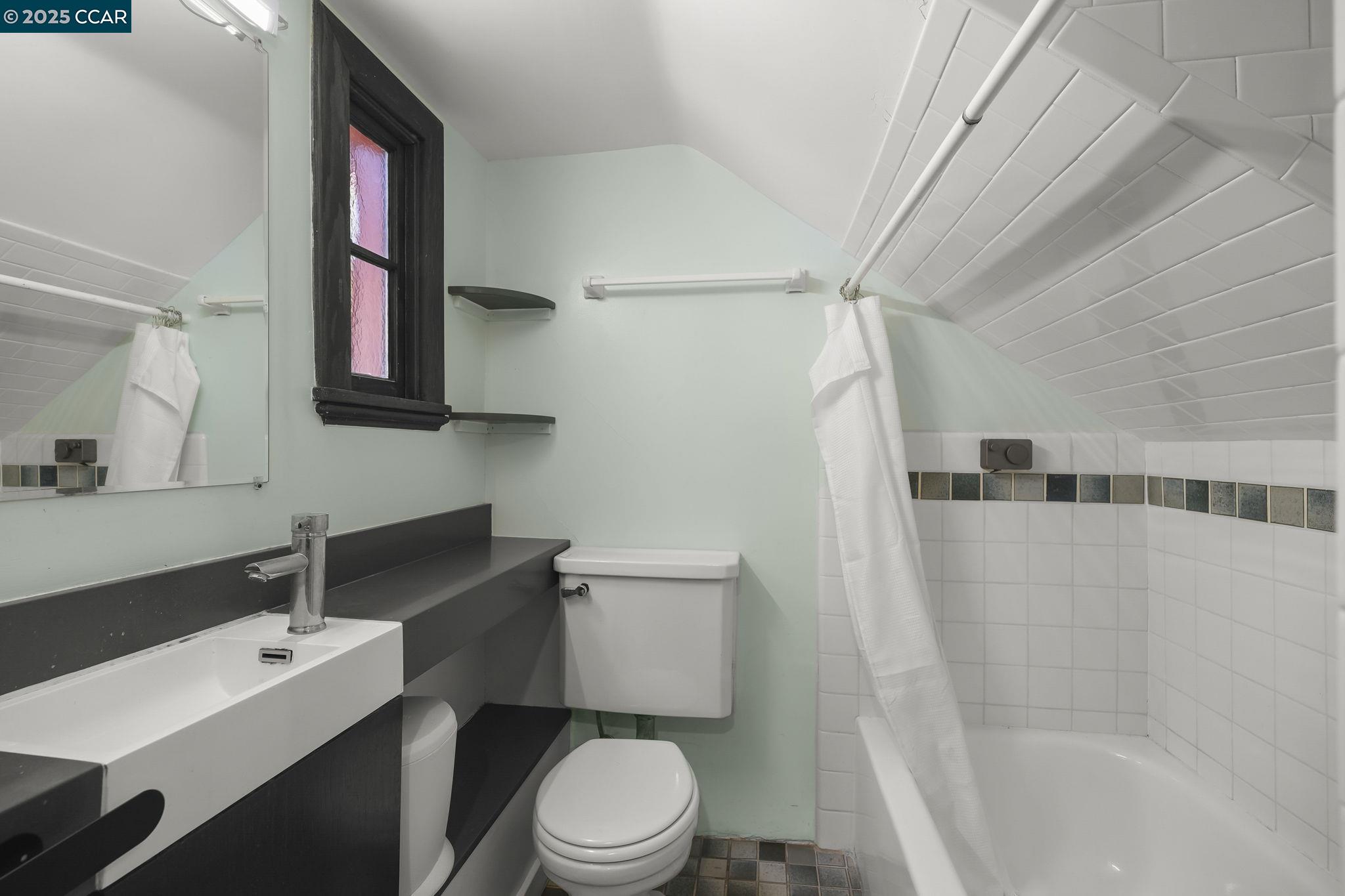 1407 Euclid Avenue Berkeley, CA 94708 - Photo 14 of 16 a bathroom with a granite countertop sink toilet a mirror and shower