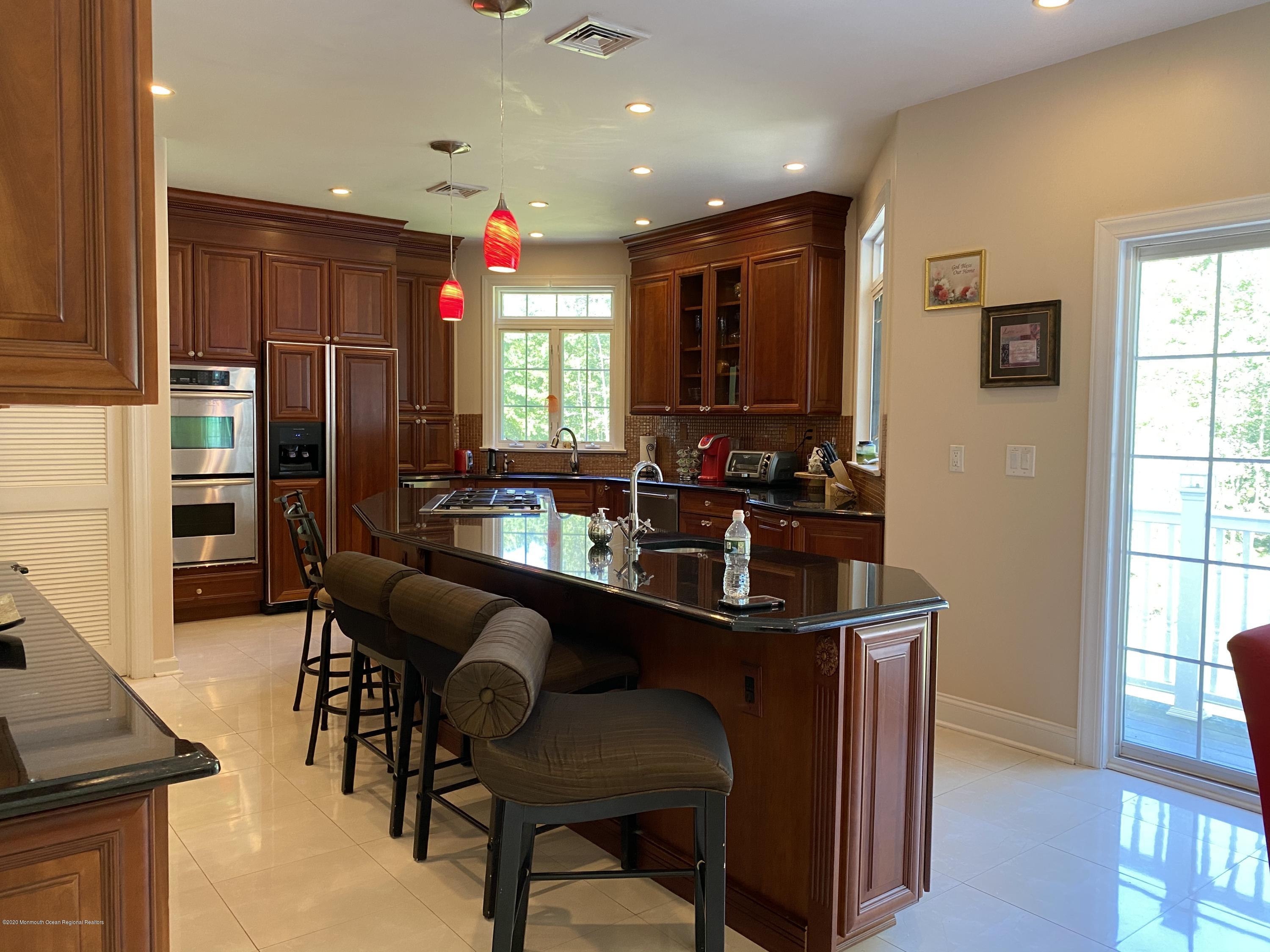 436 Stagecoach Road Millstone Township, NJ 08510 - Photo 36 of 97 a kitchen with stainless steel appliances kitchen island granite countertop a dining table and chairs