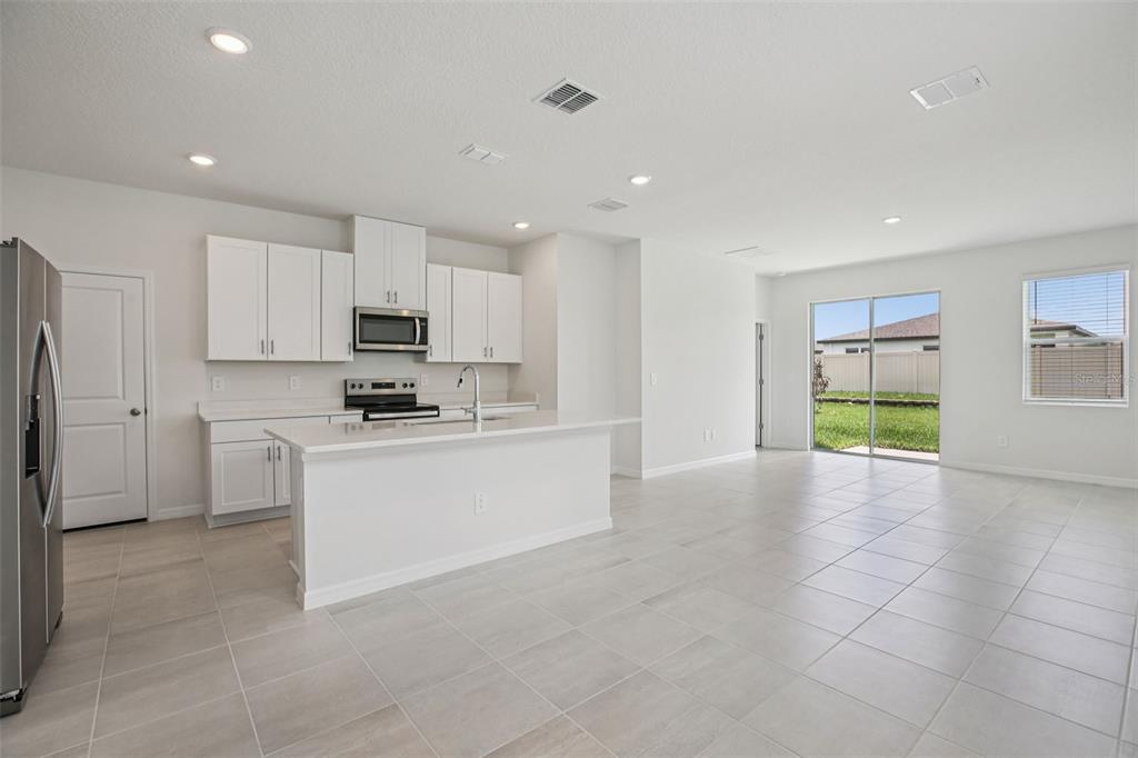 1820 Brekey Way Zephyrhills, FL 33541 - Photo 13 of 41 a large white kitchen with a refrigerator a stove a sink and a window