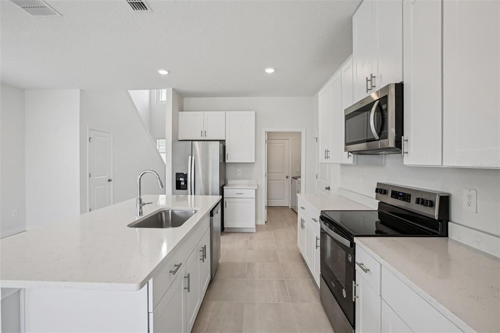 1820 Brekey Way Zephyrhills, FL 33541 - Photo 18 of 41 a kitchen with stainless steel appliances sink stove microwave and refrigerator