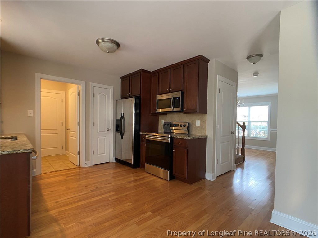 56 Orchard Falls Drive Spring Lake, NC 28390 - Photo 12 of 24 a kitchen with stainless steel appliances a refrigerator and a stove top oven