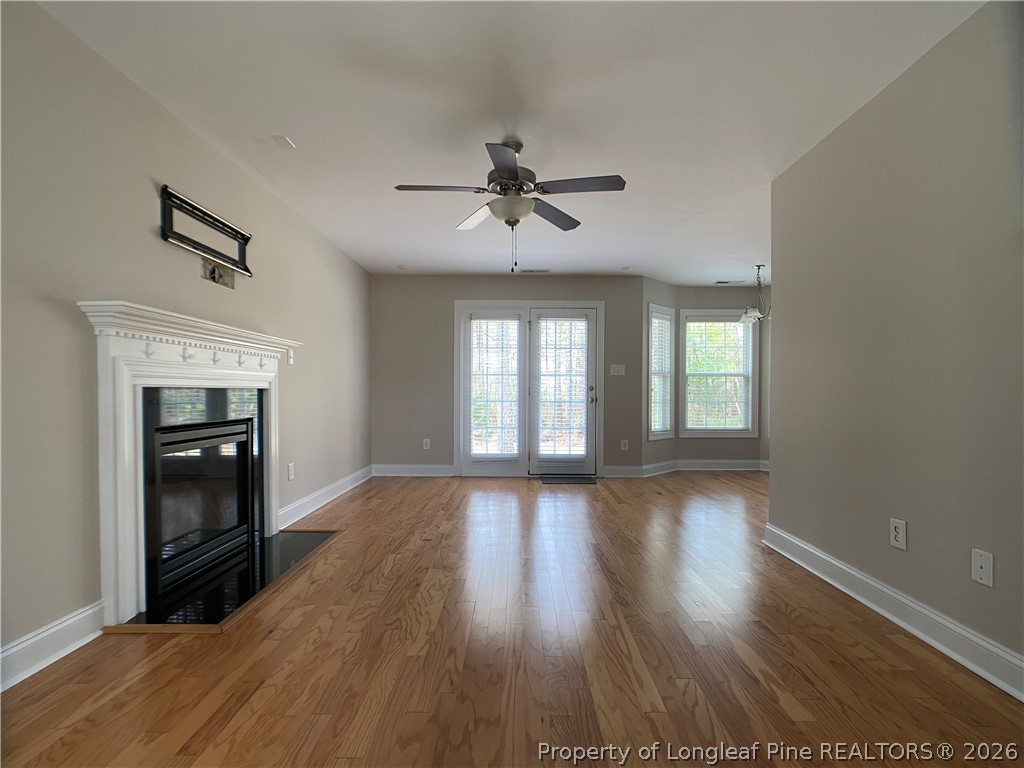 56 Orchard Falls Drive Spring Lake, NC 28390 - Photo 8 of 24 an empty room with wooden floor fireplace and windows