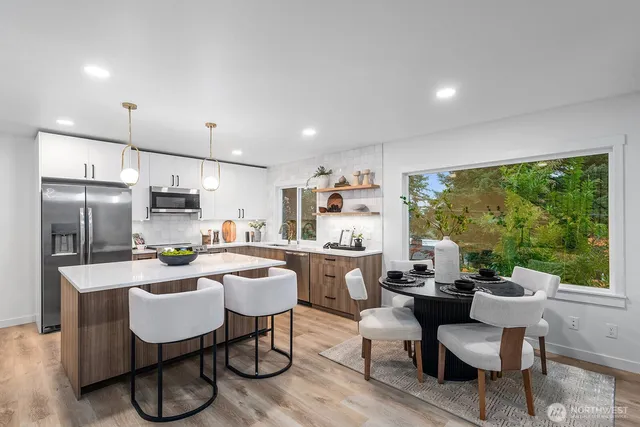 a kitchen with a table chairs refrigerator and cabinets