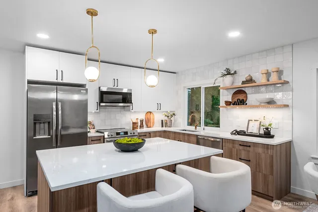 a kitchen with stainless steel appliances granite countertop a sink a stove and a wooden floors