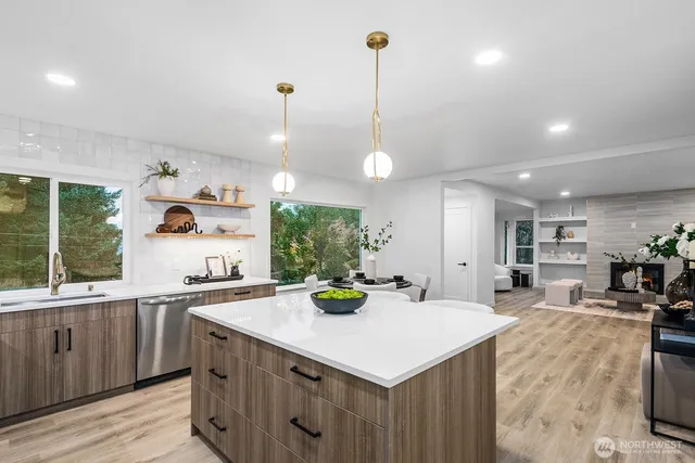 a kitchen with a sink a counter space appliances and cabinets