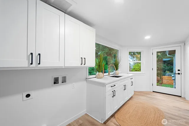 a kitchen with white cabinets and window