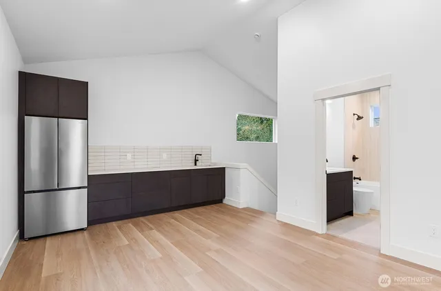 a kitchen with stainless steel appliances a refrigerator and a wooden floor