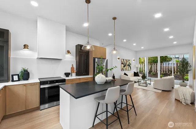a kitchen with stainless steel appliances kitchen island granite countertop a sink and a refrigerator