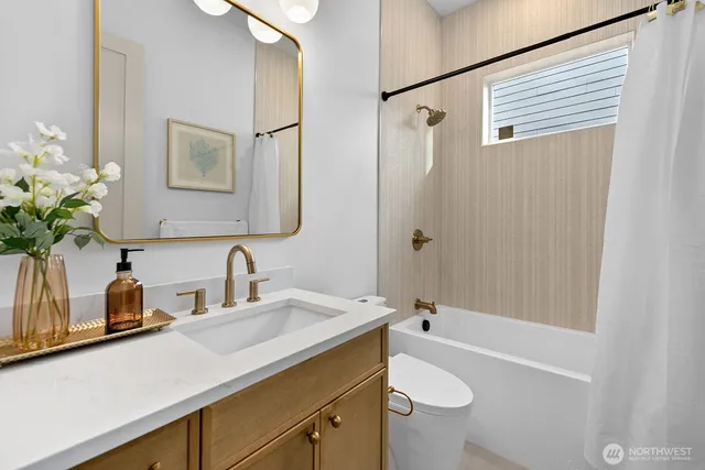 a bathroom with a granite countertop sink a toilet a mirror a vanity and shower