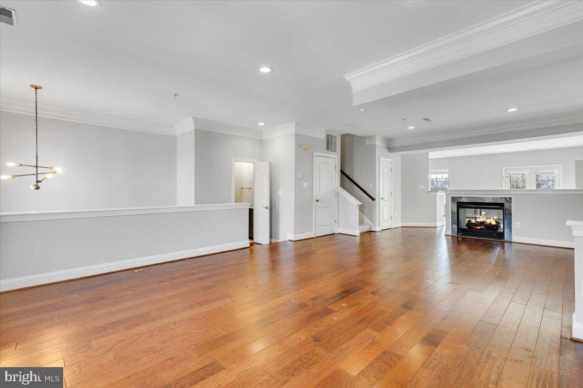 174 A Chevy Chase Street, Unit 174A Gaithersburg, MD 20878 - Photo 5 of 34 a view of an empty room with wooden floor and a kitchen