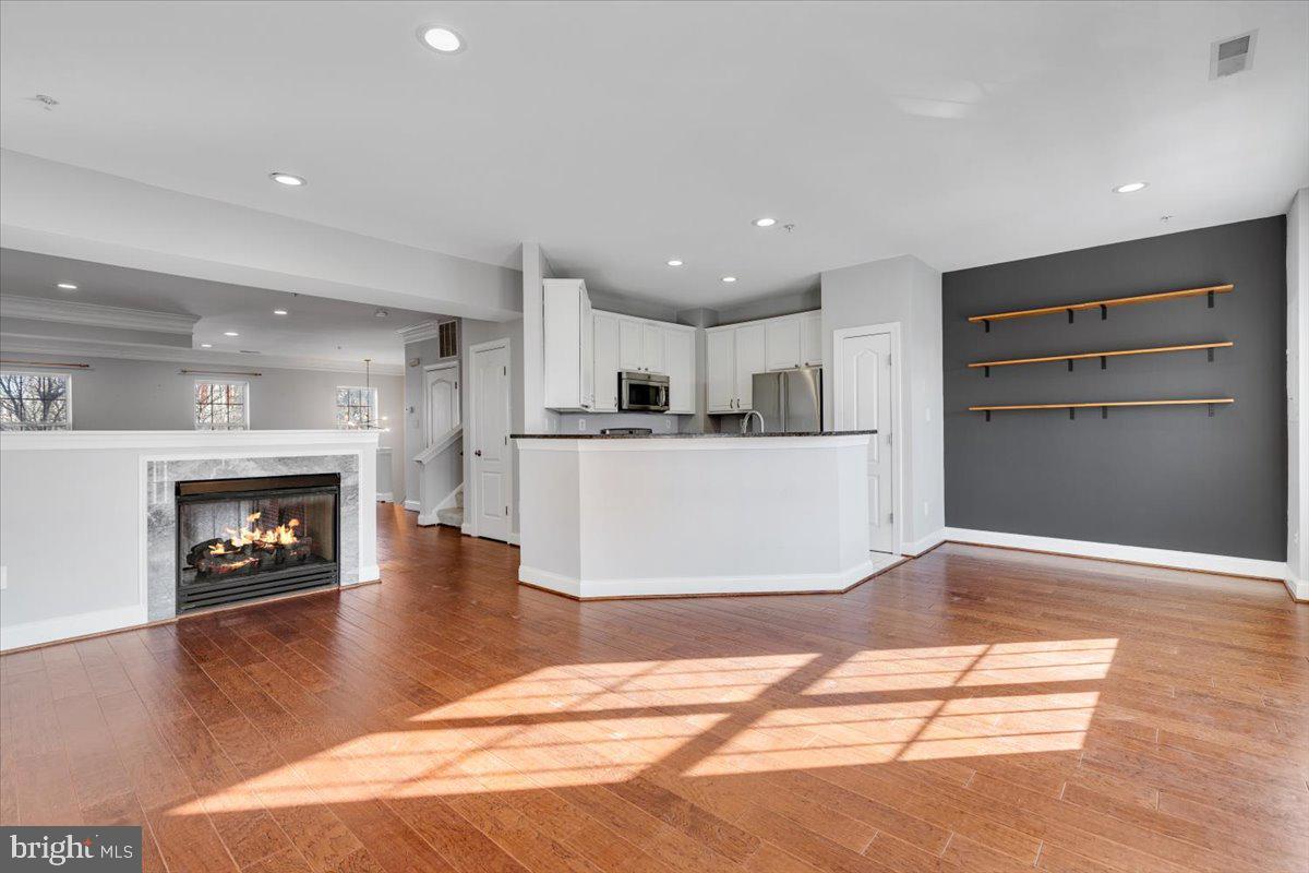 174 A Chevy Chase Street, Unit 174A Gaithersburg, MD 20878 - Photo 7 of 34 a view of a livingroom with a fireplace a kitchen and windows