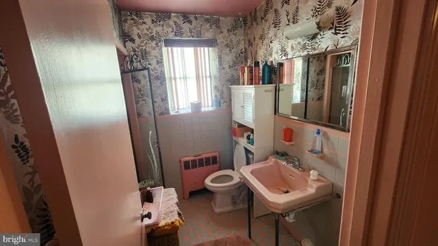 a bathroom with a sink toilet and mirror