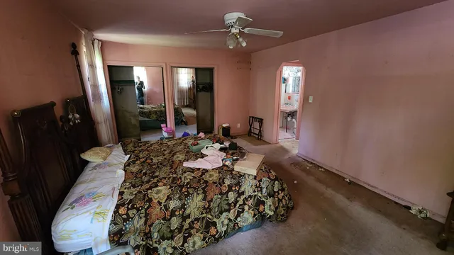 a bed sitting in a room next to a window and a chandelier