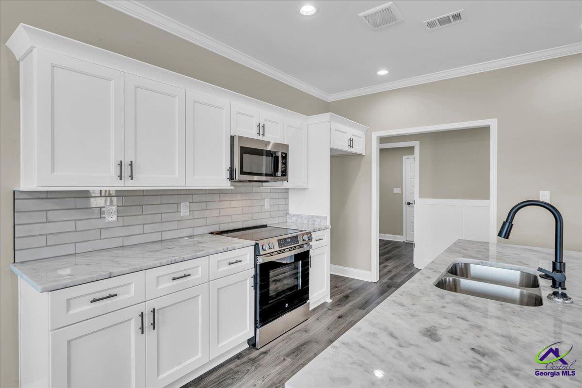 103 Early Drive Byron, GA 31008 - Photo 16 of 56 a kitchen with appliances a sink cabinets and a window