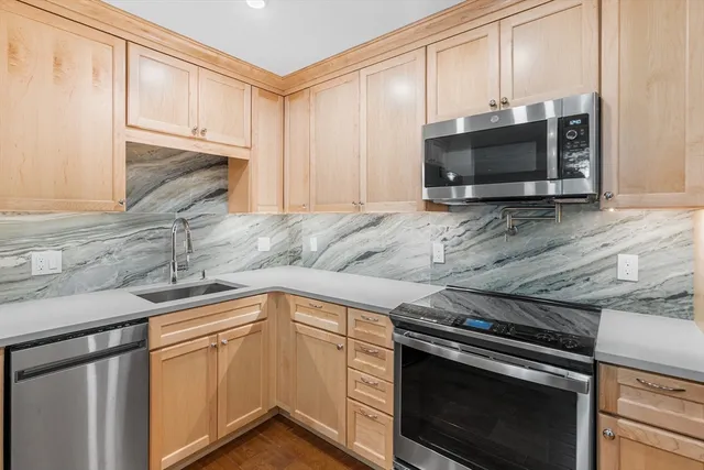 a kitchen with stainless steel appliances granite countertop a stove microwave and oven