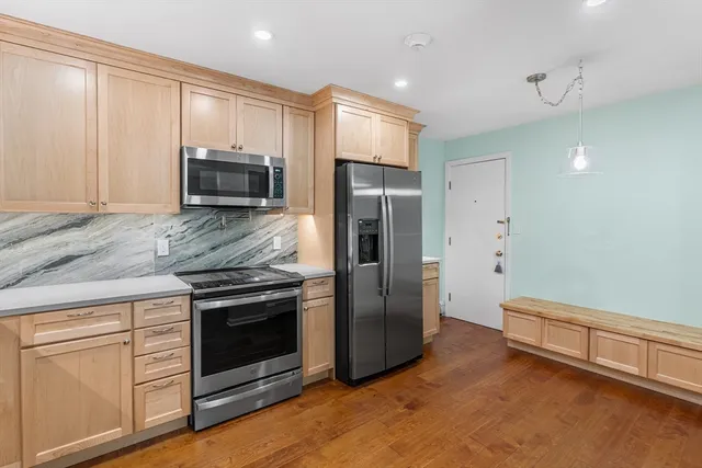 a kitchen with stainless steel appliances granite countertop a stove a microwave and a refrigerator