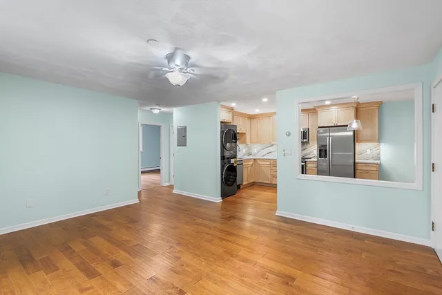 wooden floor in an empty room with a kitchen