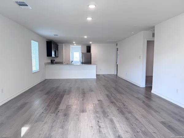 a view of empty room with wooden floor