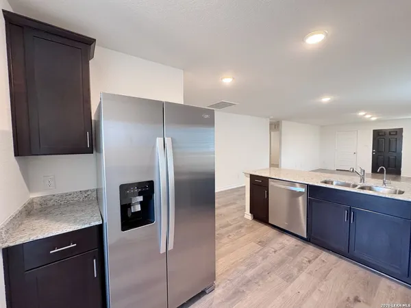 a kitchen with stainless steel appliances granite countertop a refrigerator and a sink