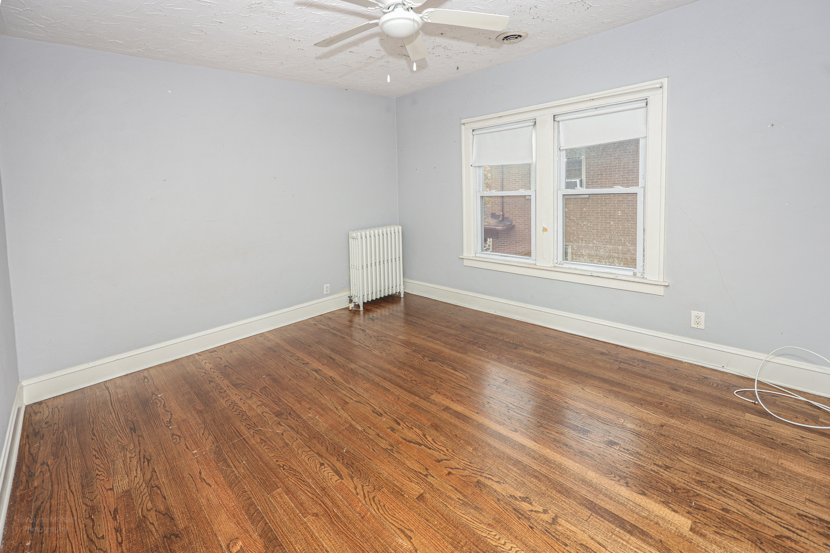 815 Mason Avenue, Unit 2 Joliet, IL 60435 - Photo 7 of 13 an empty room with wooden floor chandelier fan and windows