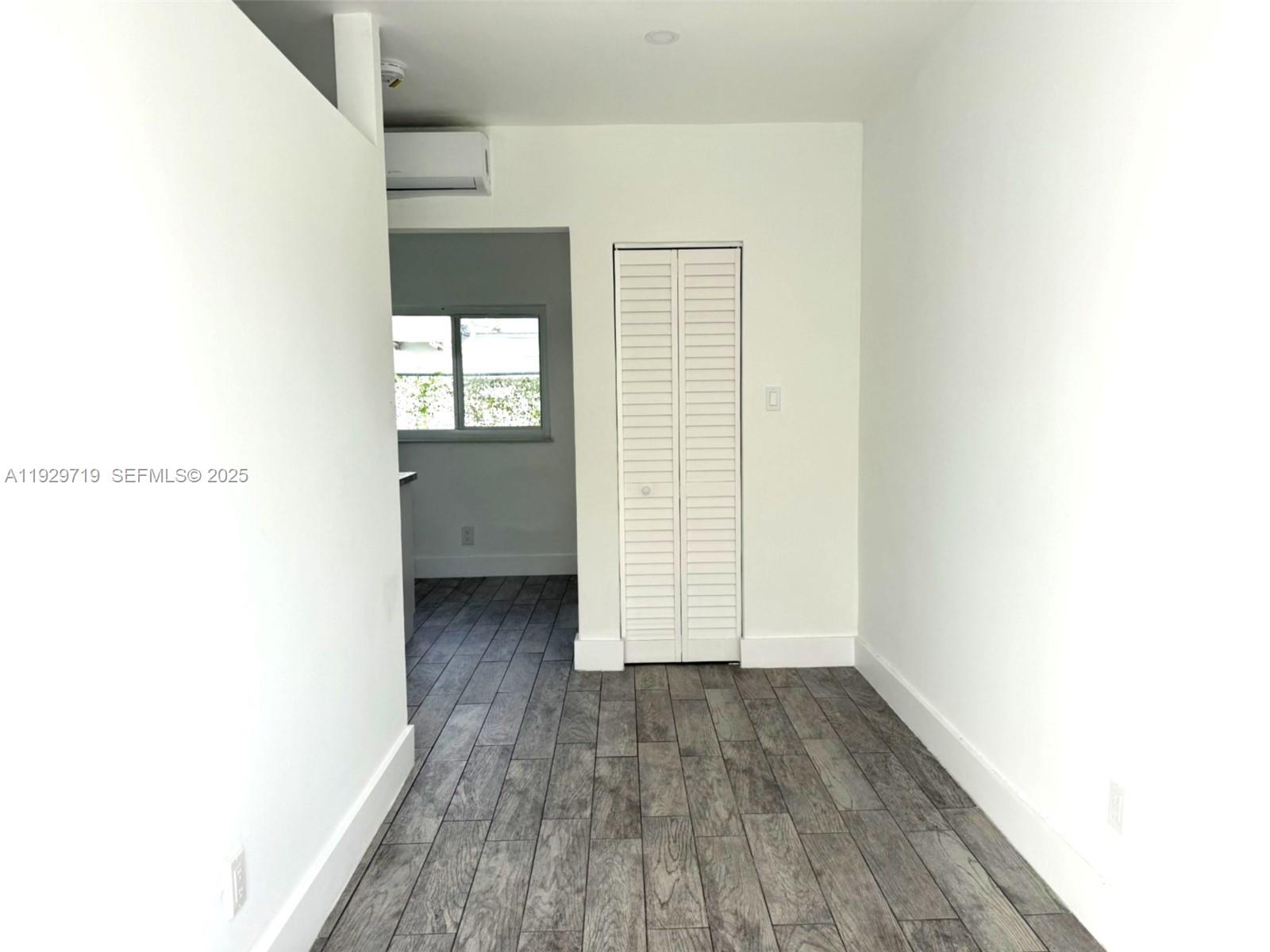 3071 Southwest 27th Lane, Unit 3 Miami, FL 33133 - Photo 2 of 7 a view of a room with wooden floor and white walls