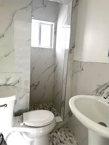 a white toilet sitting next to a bathroom sink