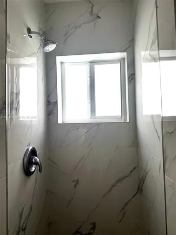 a bathroom with a window and a shower
